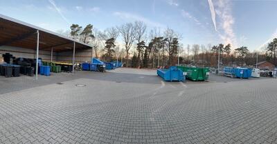 Bild vergrößern: Blick auf die AUßenfläche des Wertstoffhofes mit dem Mülltonnenlager und den Sammelcontainern